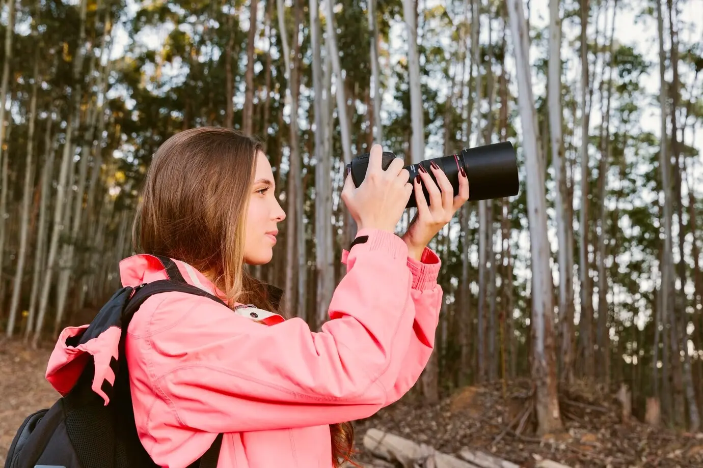 Nahaufnahme einer weiblichen Reisenden beim Fotografieren im Wald.
